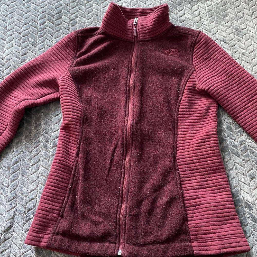 North face maroon zip up jacket.